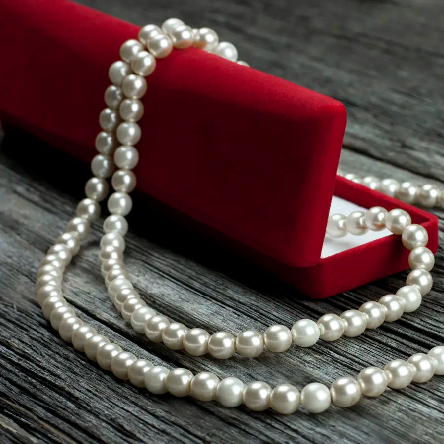 White pearls laid over a red jewelry case at Joe Kassab Jewelers